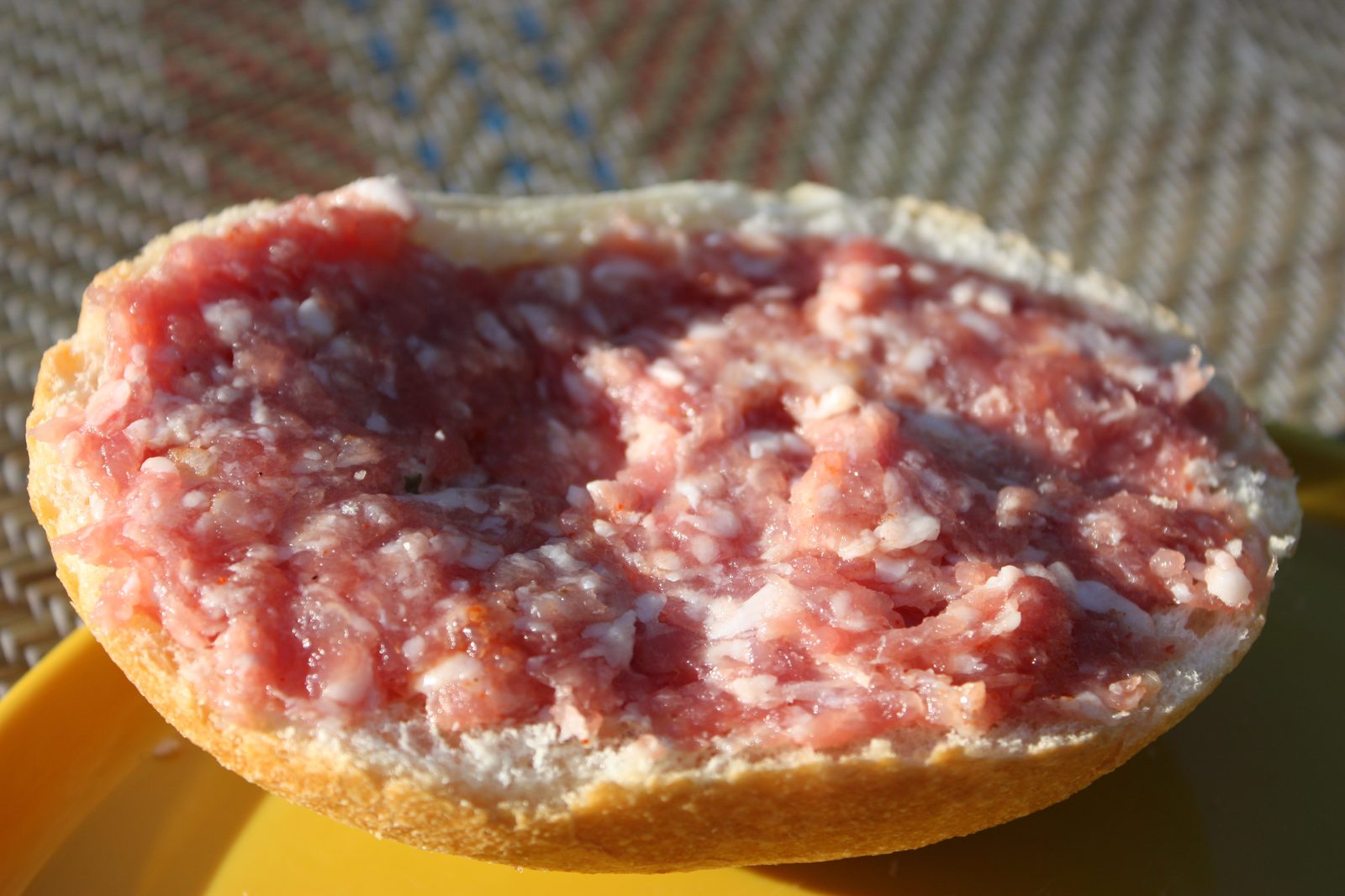Ein Mettbrötchen mit rohem Hackfleisch und Zwiebeln